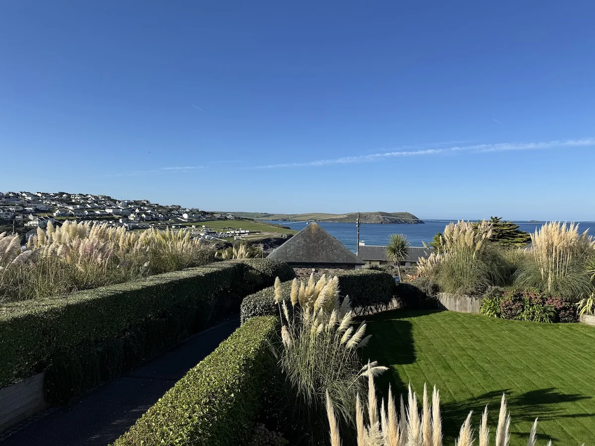 Freshly cut hedges and a neat lawn in a coastal Cornish garden overlooking the sea